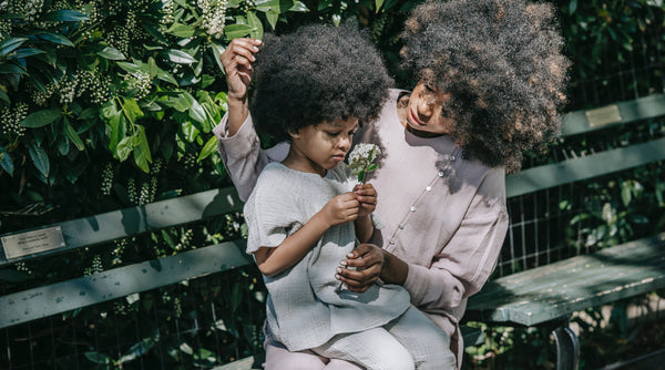 Mother and daughter enjoying flowers on a sunny day