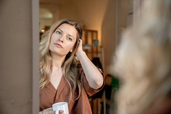 Woman checking hair in mirror