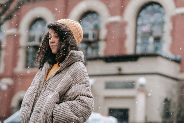 Young woman wearing winter coat and hat on snowy day