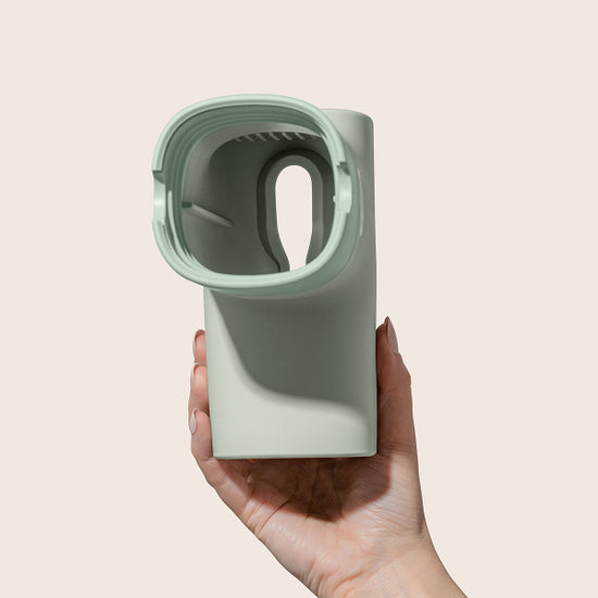 Hand holding the Bath Tub Filter in Jade on a beige background