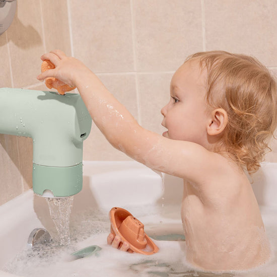 Child playing with toys during bath time next to the Bath Tub Filter in Jade