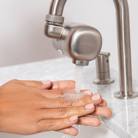 Model washing hands under the Faucet Filter in Brushed Nickel