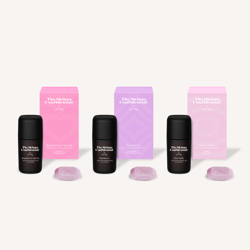 The Skinny Confidential Summer Aroma Kit featuring three black diffuser bottles with matching pink and purple packaging boxes, accompanied by light purple aroma tablets, perfect for creating a luxurious summer ambiance. Exclusively by Canopy.