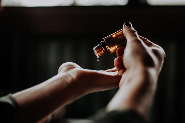 Woman Applying Essential Oil Drops on Palm