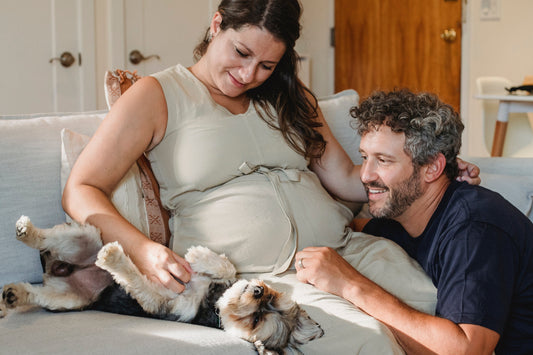 Pregnant woman at home with partner and dog