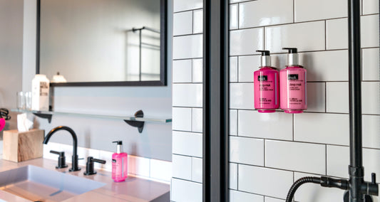 Black and white bathroom stocked with pink toiletries