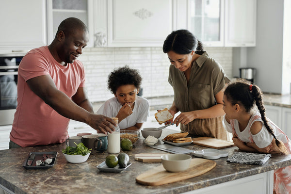 Parents and children preparing meal in clean kitchen