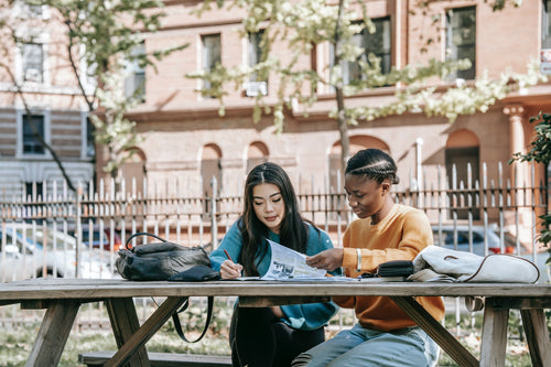 Young women sitting at picnic table on college campus