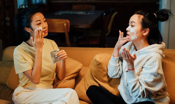 Women applying skincare products in living room