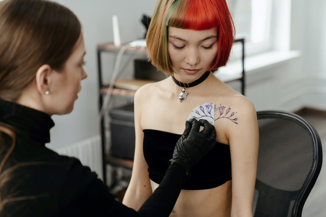 Young woman getting tattoo on shoulder