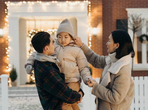 Family outside a house in winter