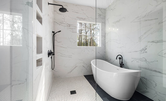 Minimalist white bathroom with marble tile walls and matte black plumbing fixtures