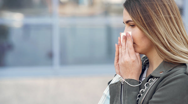 Woman sneezing outside