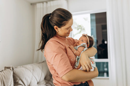 Mother cradling newborn in nursery