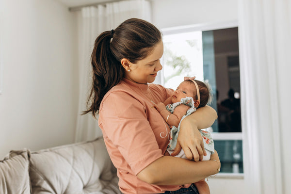 Mother cradling newborn in nursery