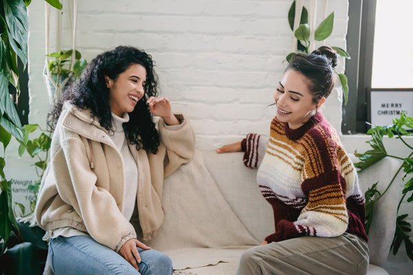 Two women on sofa in warm clothing for winter