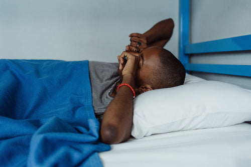 Young man waking up after a poor night's sleep