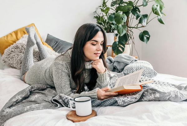 Woman reading in a cozy bed