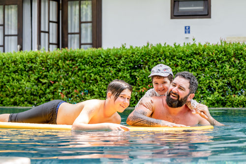 Father and sons in swimming pool