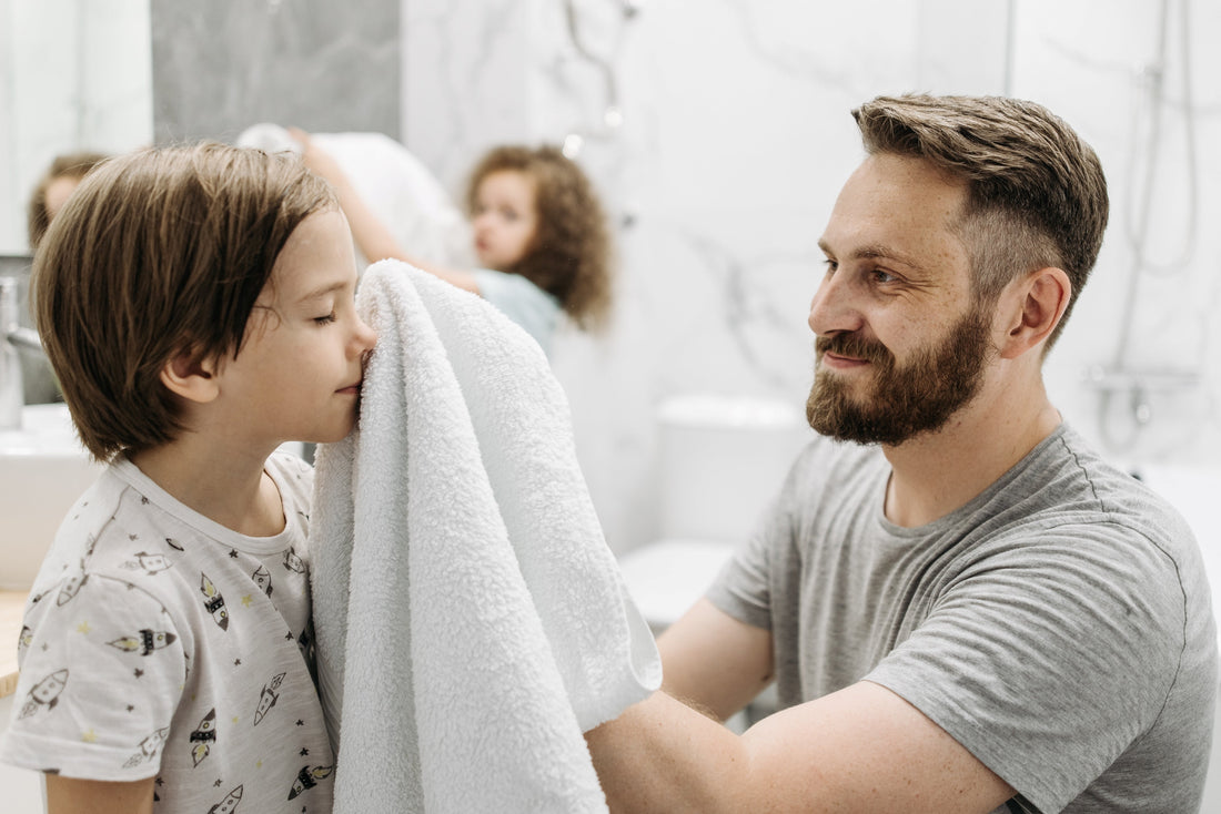 Father helping young children get ready for bed