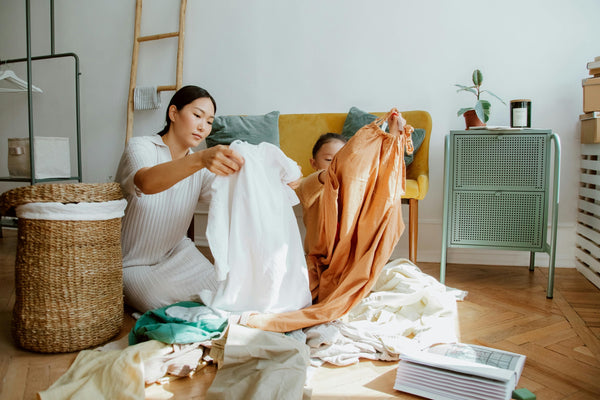 Mother and daughter sorting laundry in apartment