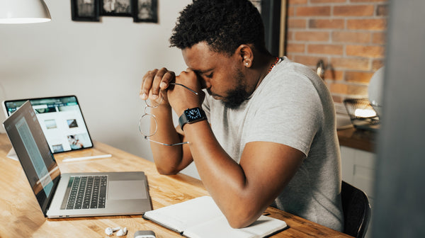 Man experiencing dry, tired eyes while working on computer