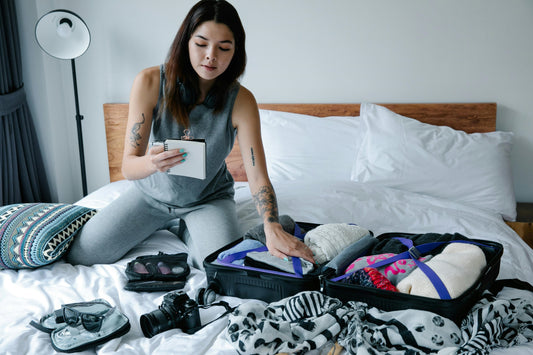 Woman on bed with suitcase and packing list