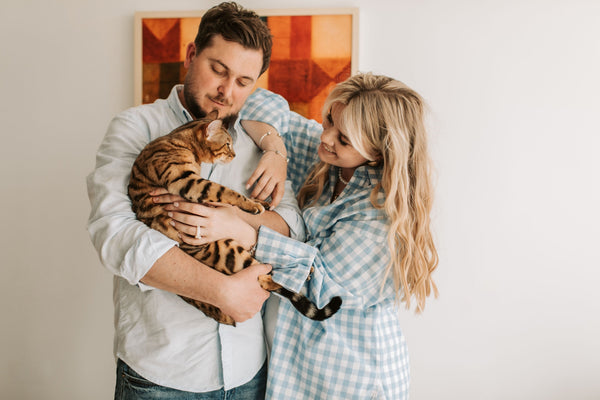 Couple holding striped cat