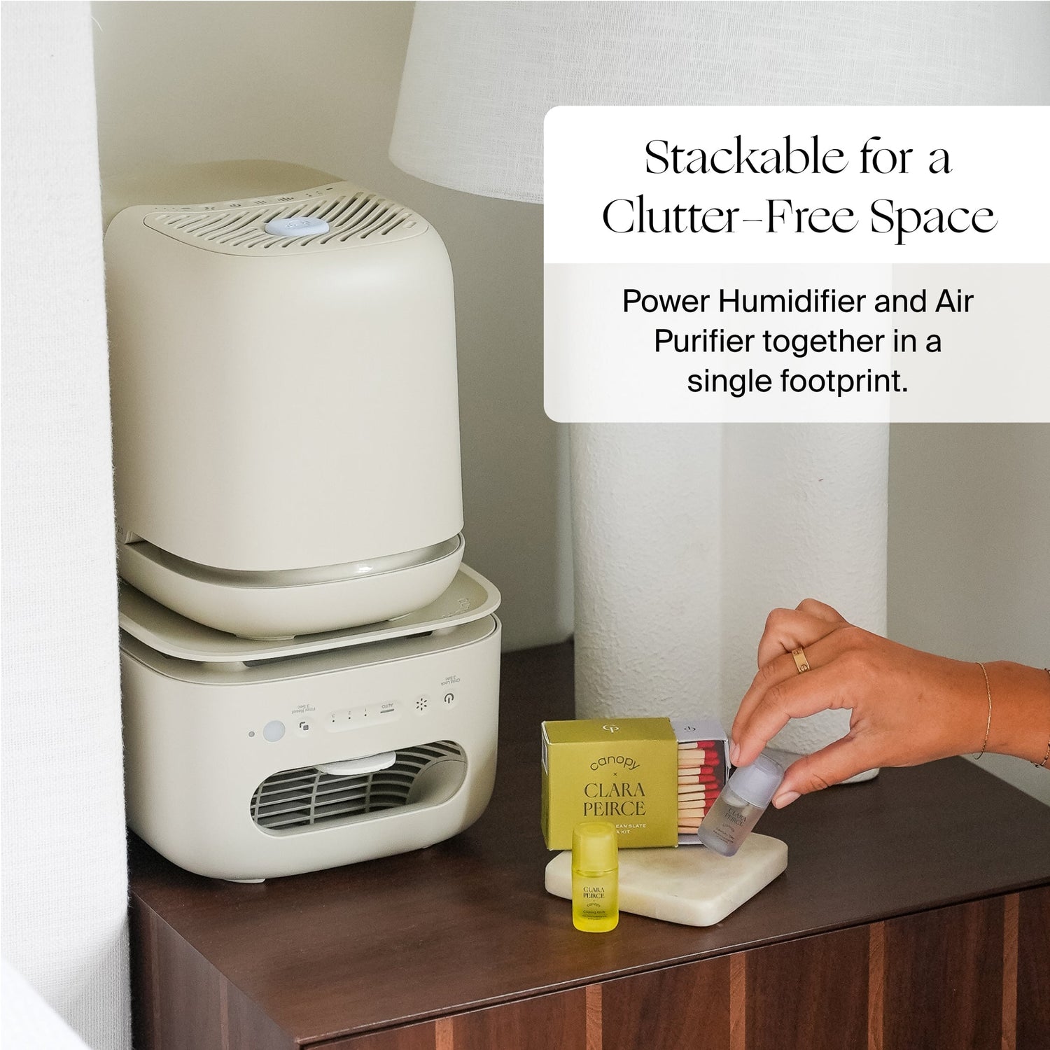 Clara Peirce x Canopy Air Purifier | Lifestyle, stackable for a clutter-free space: power Humidifier and Air Purifier together in a single footprint; Stackable power humidifier and air purifier on a table with a hand holding a product.