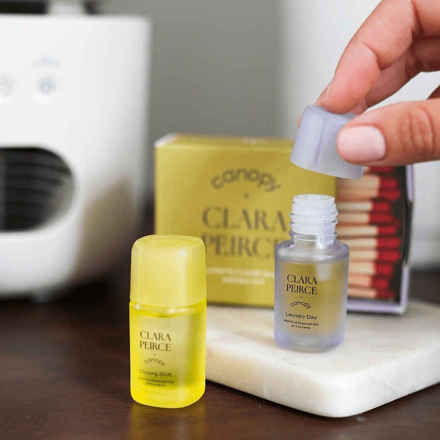 Clean Slate Aroma Kit | Lifestyle, Two small bottles of Clara Pierce products on a surface with a blurred background.