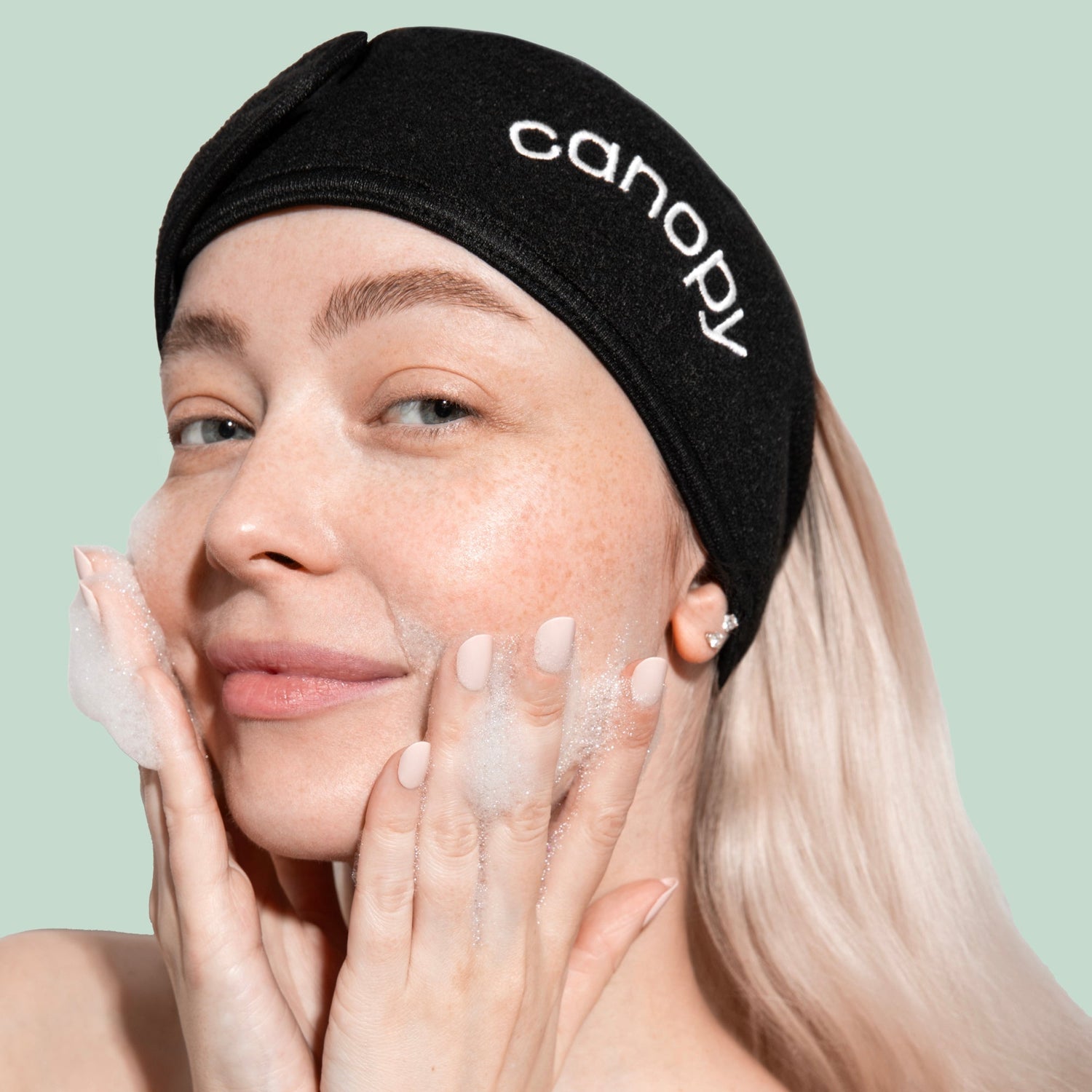 Headband | In use, helping pull hair back while model is washing their face