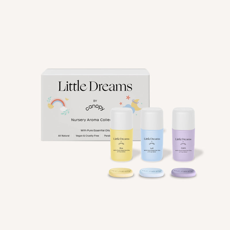 Little Dreams Aroma Kit featuring two gentle essential oil blends in blue and yellow bottles with matching pods, displayed with charming nursery-themed packaging including rainbow and cloud illustrations. Perfect for creating a soothing environment for babies, by Canopy.