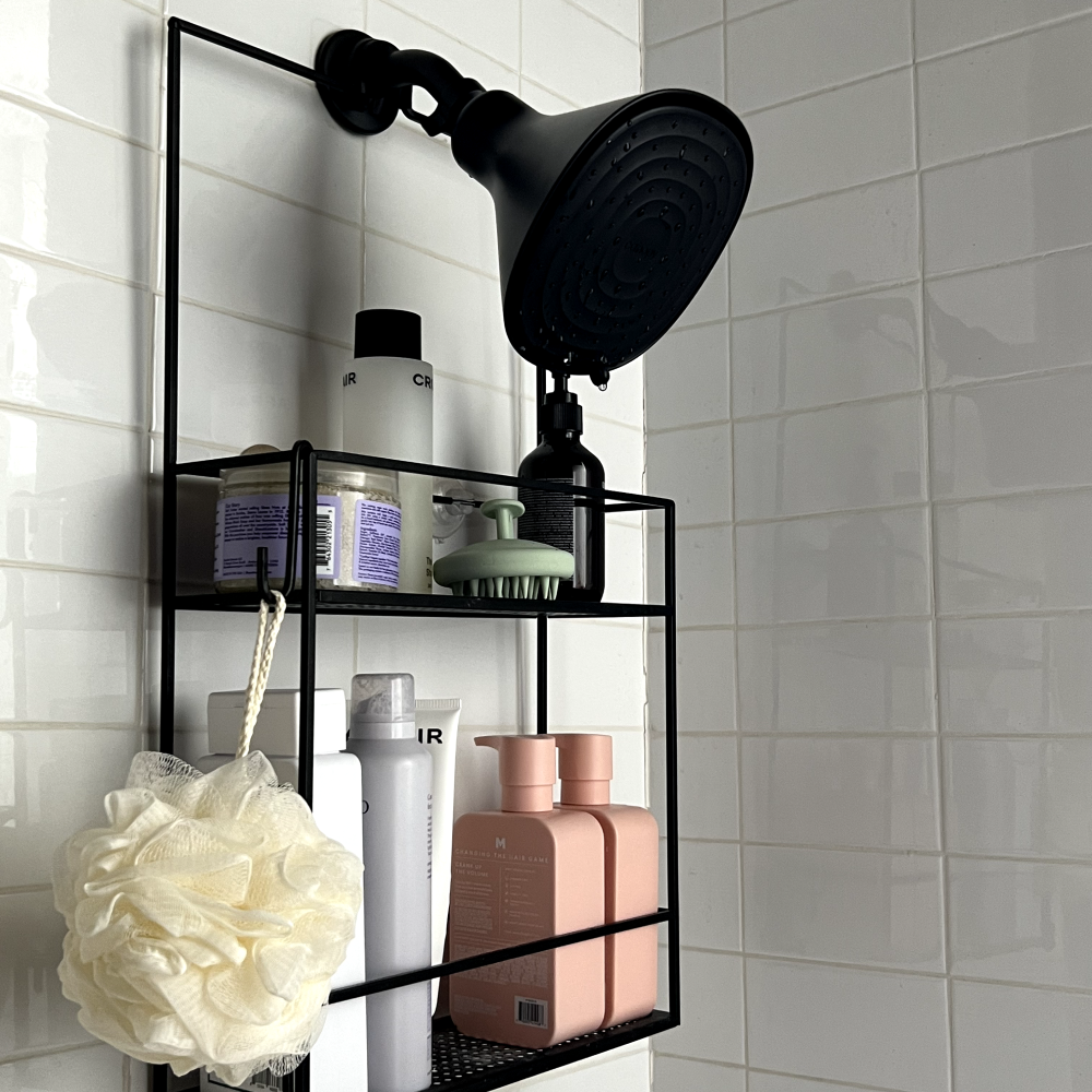 Matte Black filtered shower head in a shower with caddy and products