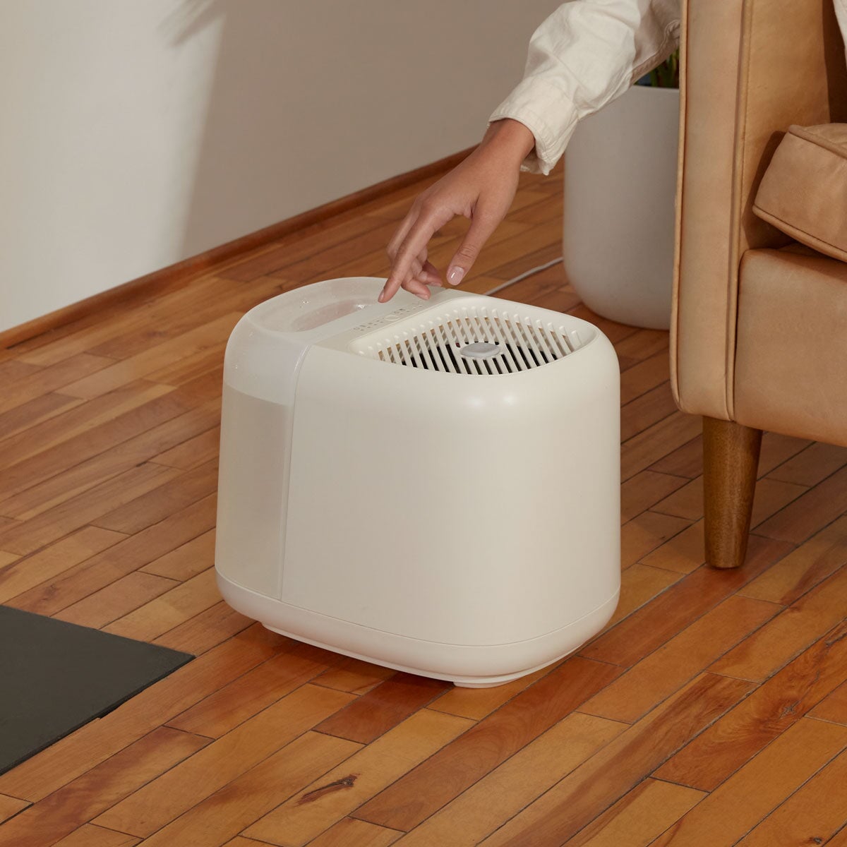 Large Room Humidifier | Lifestyle, Woman reaching for device placed on the ground